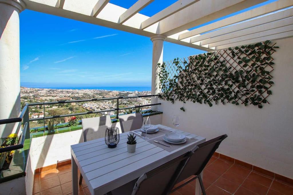 a white table and chairs on a balcony with a view at Ap. con vistas panorámicas in Benalmádena