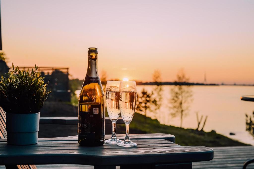 a bottle of champagne and two glasses on a table at Doles skati in Salaspils