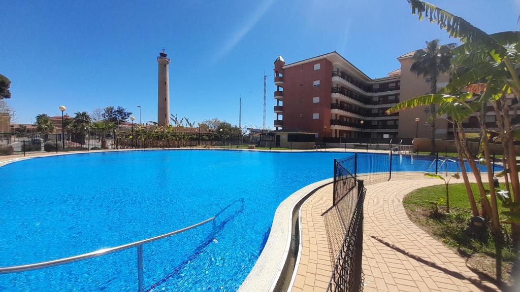 a large blue swimming pool next to a building at El Faro de Canet in Canet de Berenguer