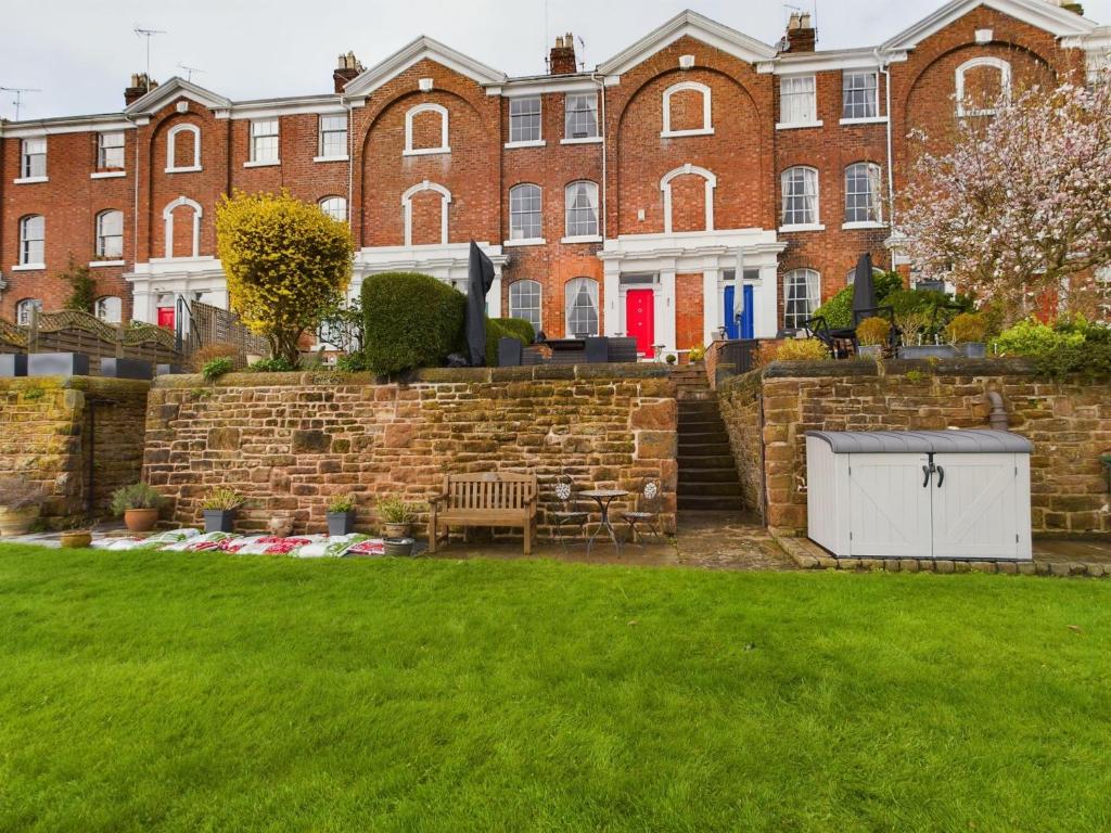 ein Haus mit Ziegelwand und Hof in der Unterkunft Rondeva in Chester