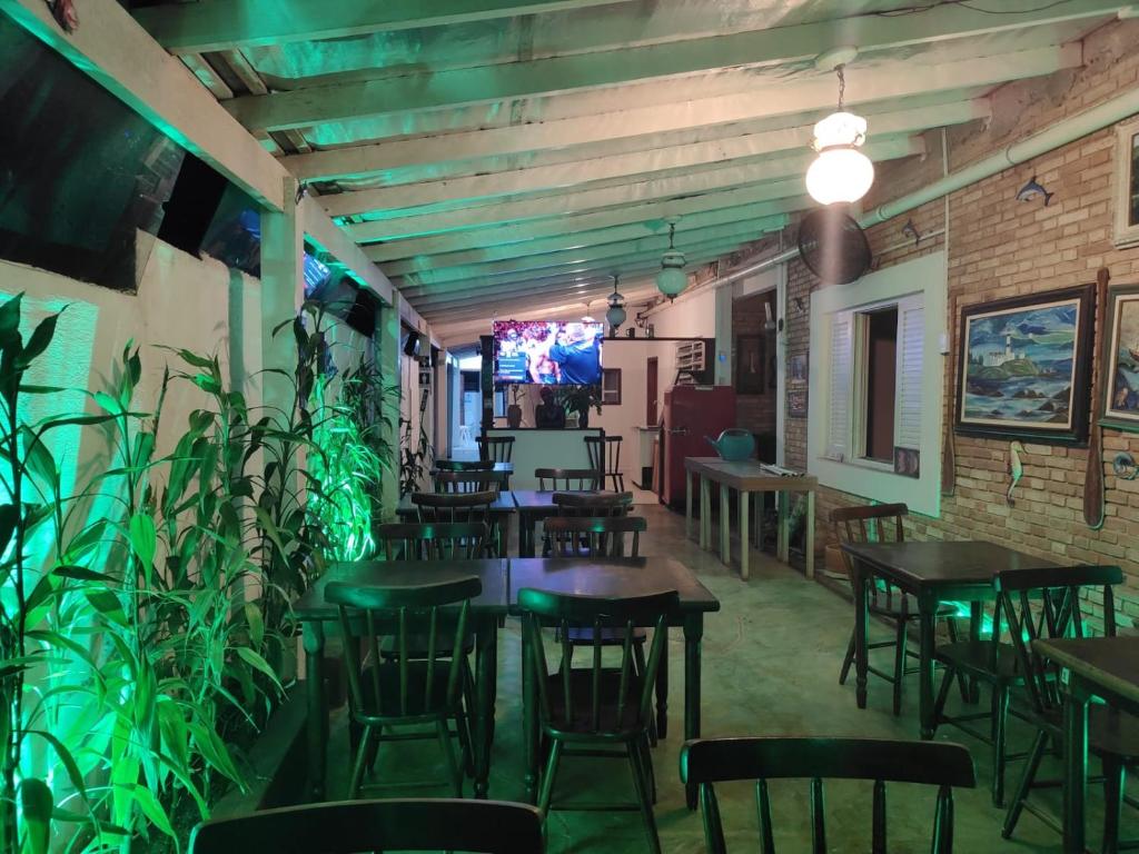 um restaurante com mesas, cadeiras e plantas em Renoah Pousada em Ubatuba