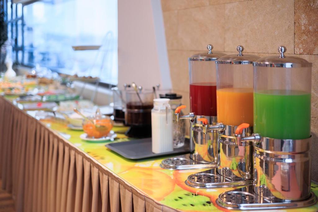 un mostrador con tres tazas llenas de líquidos de diferentes colores en Hotel Brilant Saranda, en Sarandë