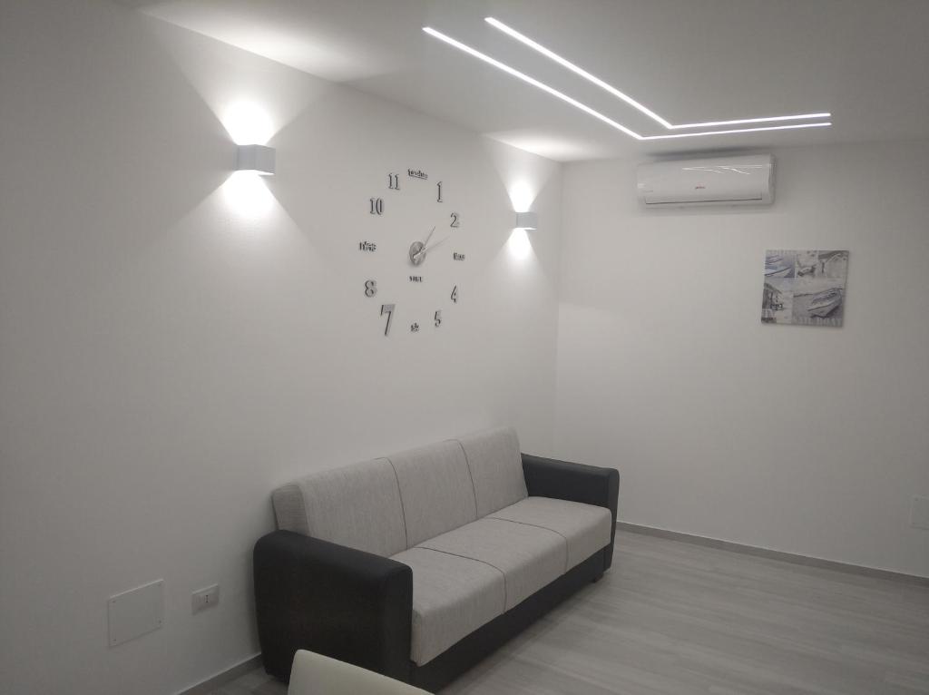 a waiting room with a couch and clocks on the wall at Casa vacanze Venere in Balestrate