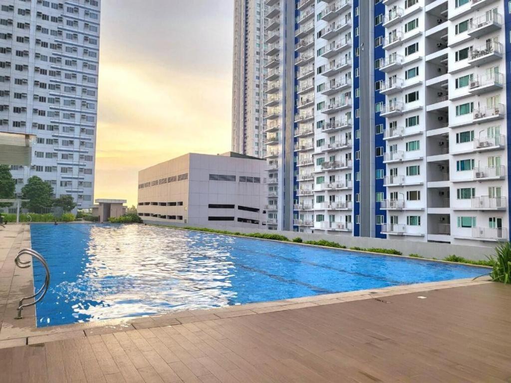 a swimming pool in the middle of two tall buildings at Grass Residences by Team A in Manila