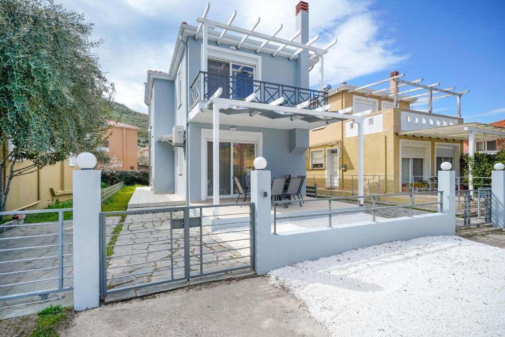 a villa with a gate in front of a house at Nik-Ntin Villa Deluxe in Prinos