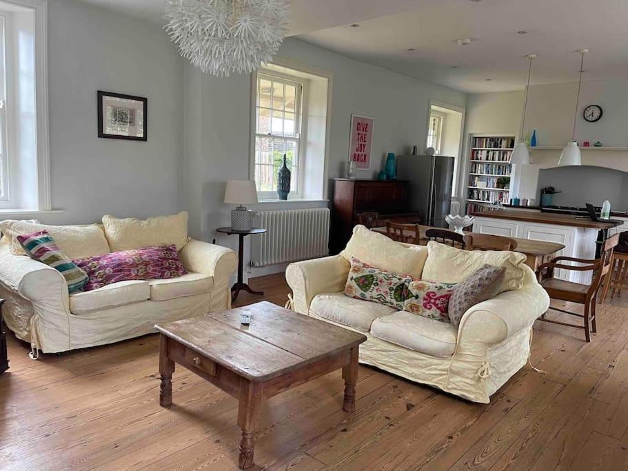 a living room with two couches and a table at Station House, Gilling in Gilling East
