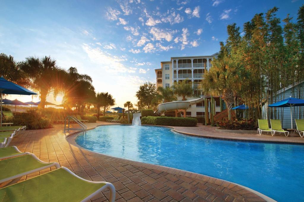 una piscina en un complejo con sillas y un edificio en Marriott's Harbour Lake en Orlando
