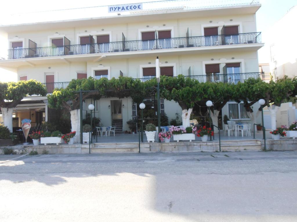 a large white building with trees in front of it at Pyrassos in Nea Anchialos