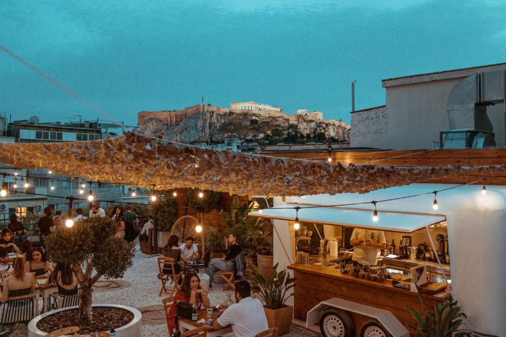 ein Restaurant mit Tischen und einem Imbisswagen in der Unterkunft Ergon House Athens in Athen