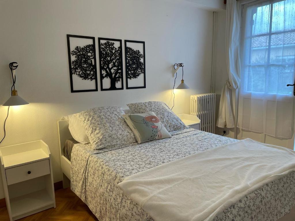 1 dormitorio con 1 cama con 3 cuadros en la pared en 32 parc des sports chez catherve, en Saint-Médard-de-Guizières