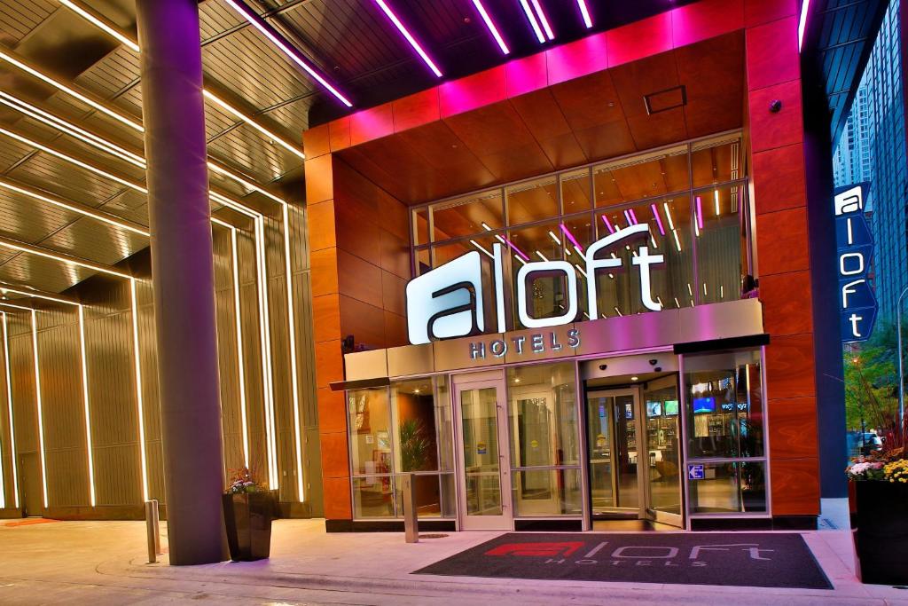 a store front of a hotel with a neon sign at Aloft Chicago Mag Mile in Chicago