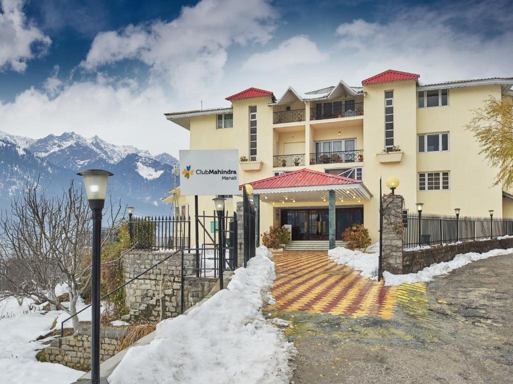 a large building with snow on the ground at Club Mahindra Snow Peaks Manali in Manāli