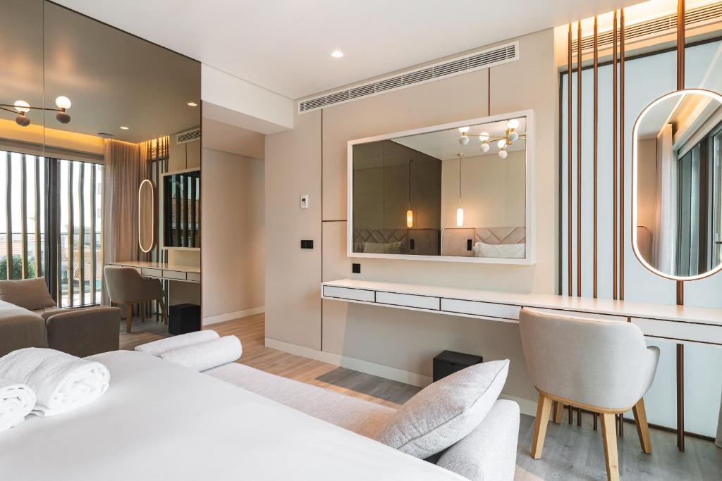 A bedroom corner with a wall-mounted vanity desk, mirrors, and a chair.