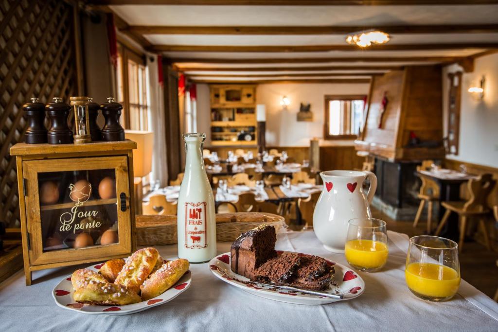 a table with plates of food and a bottle of orange juice at Les Monts Charvin in Courchevel