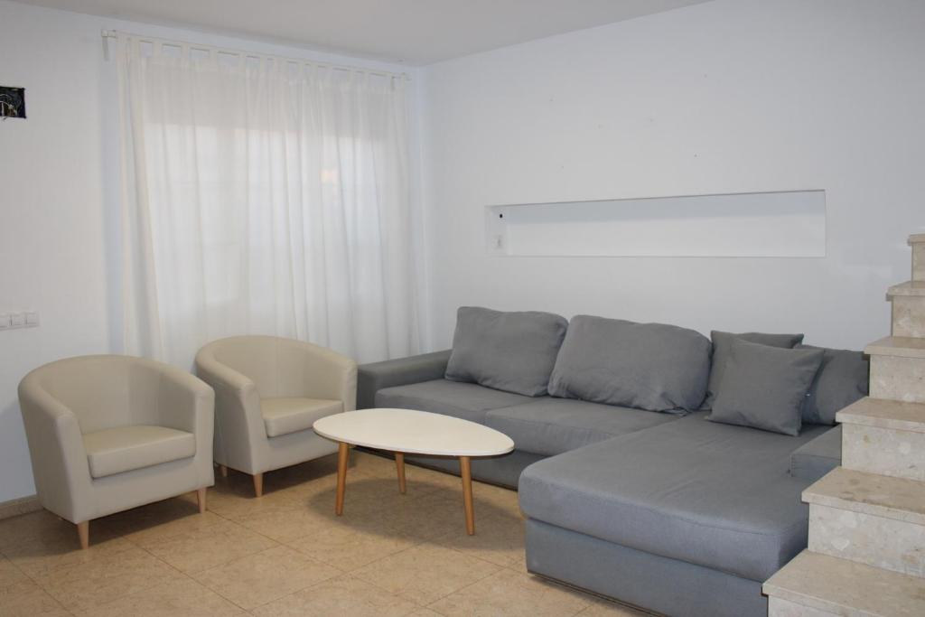 sala de estar con sofá, 2 sillas y mesa en Chalet adosado en Cullera