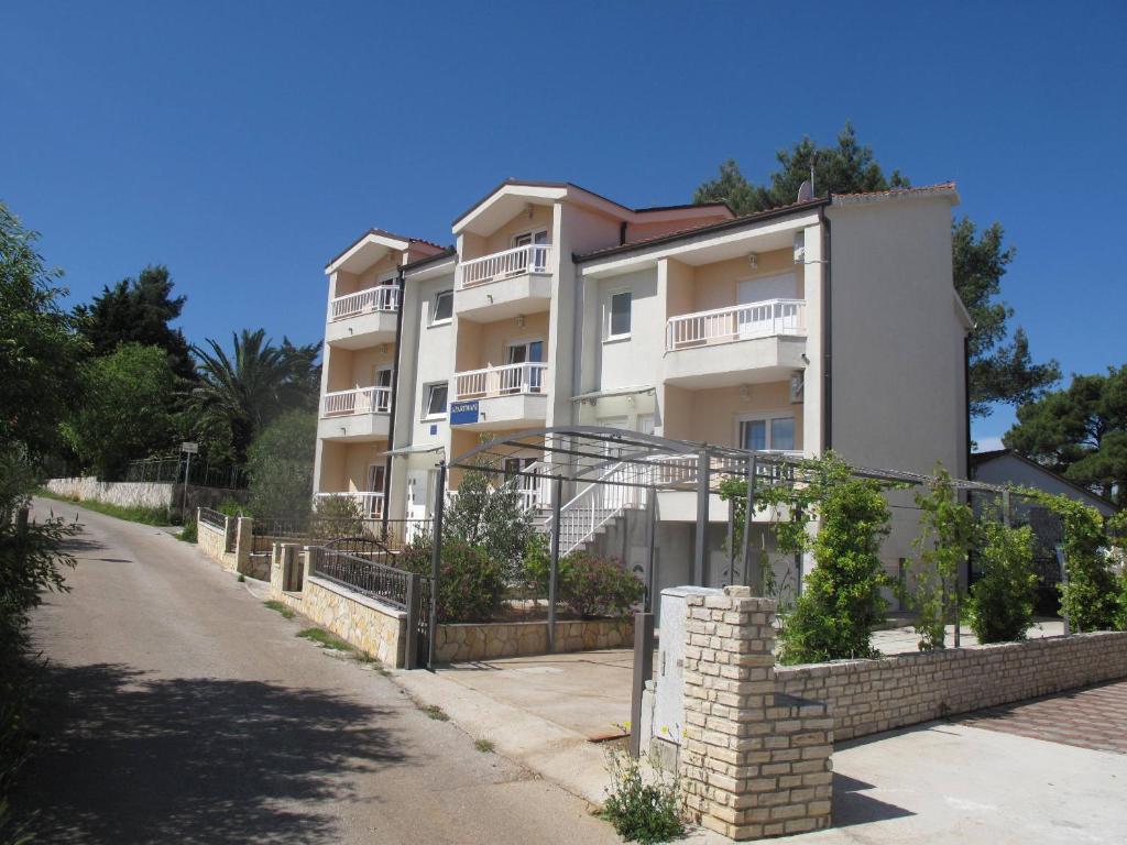 a white apartment building with a brick wall at Apartments Mia in Stari Grad