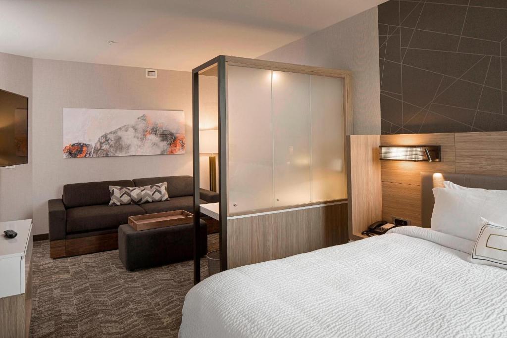 a hotel room with a bed and a couch at SpringHill Suites by Marriott Kalispell in Kalispell
