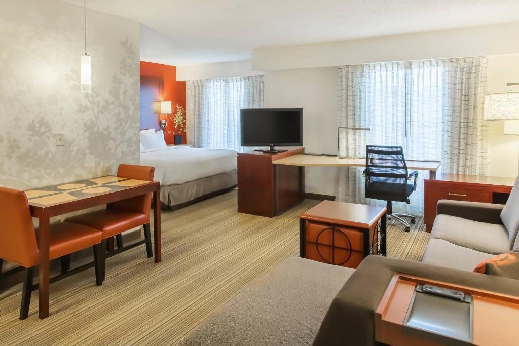 a hotel room with a bed and a living room at Residence Inn Sioux Falls in Sioux Falls