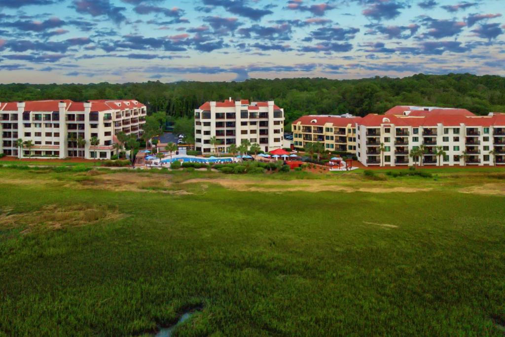 a group of buildings in a field next to a park at Marriott's Harbour Point and Sunset Pointe at Shelter Cove in Hilton Head Island