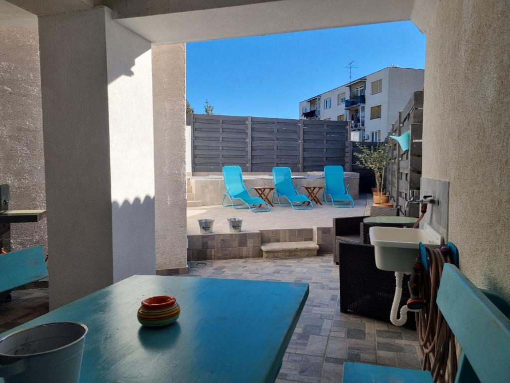 un patio con sillas azules, mesa y fregadero en Villa Carmen, en Pula