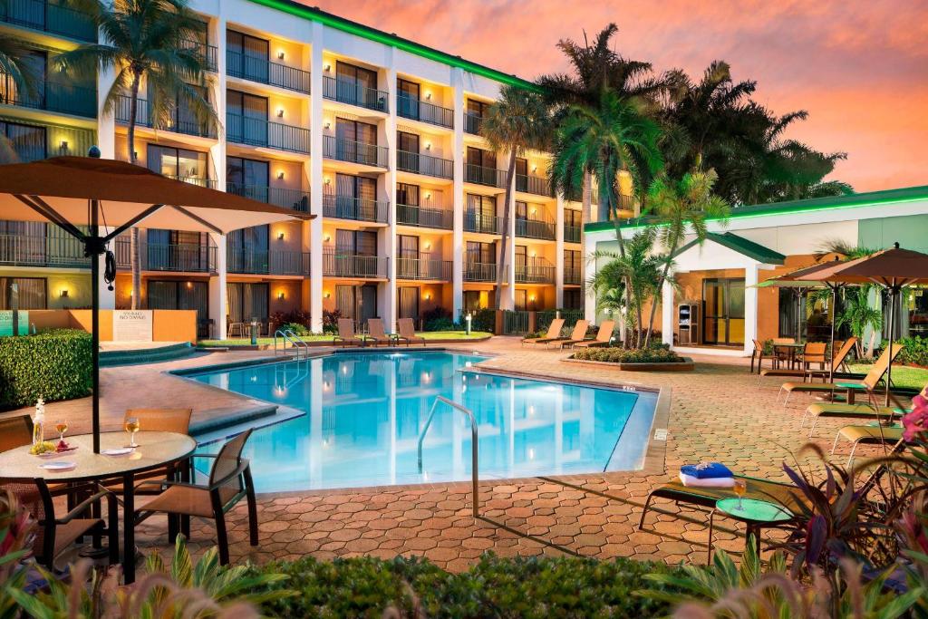 an exterior view of a hotel with a swimming pool at Courtyard by Marriott Fort Lauderdale East / Lauderdale-by-the-Sea in Fort Lauderdale
