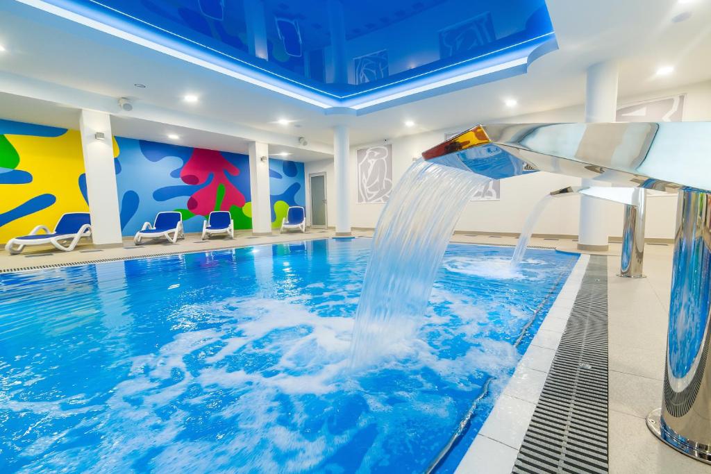 una piscina con un tobogán de agua en una habitación de hotel en Hotel New Skanpol, en Kołobrzeg