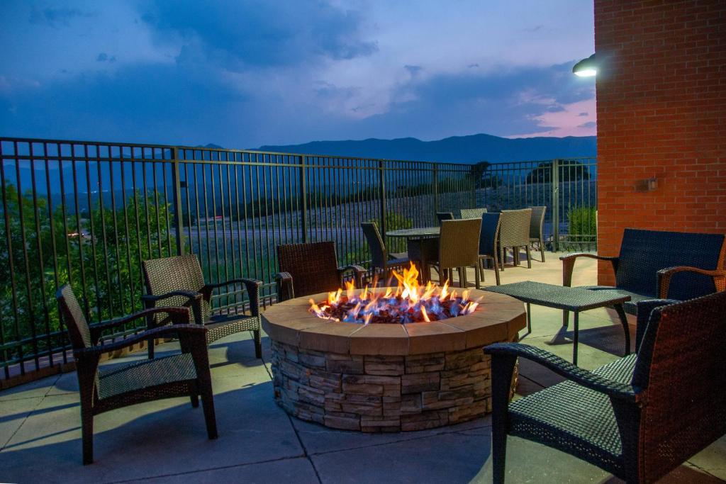 eine Feuerstelle mit Stühlen und Tischen auf einer Terrasse in der Unterkunft Fairfield Inn and Suites by Marriott Colorado Springs North Air Force Academy in Colorado Springs