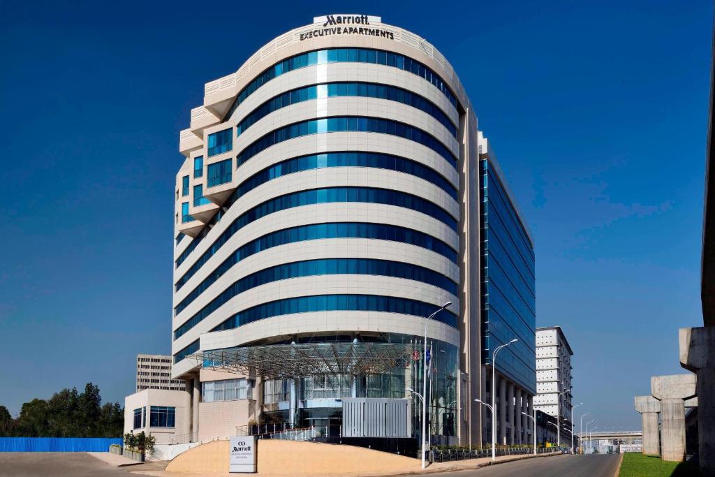 a tall white building with blue windows at Marriott Executive Apartments Addis Ababa in Addis Ababa