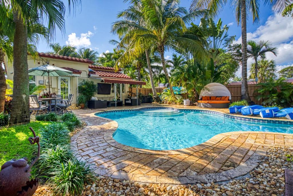a swimming pool in a yard with palm trees at Gorgeous 3 Bedroom Home On 17TH Ave Heated Pool in Hollywood