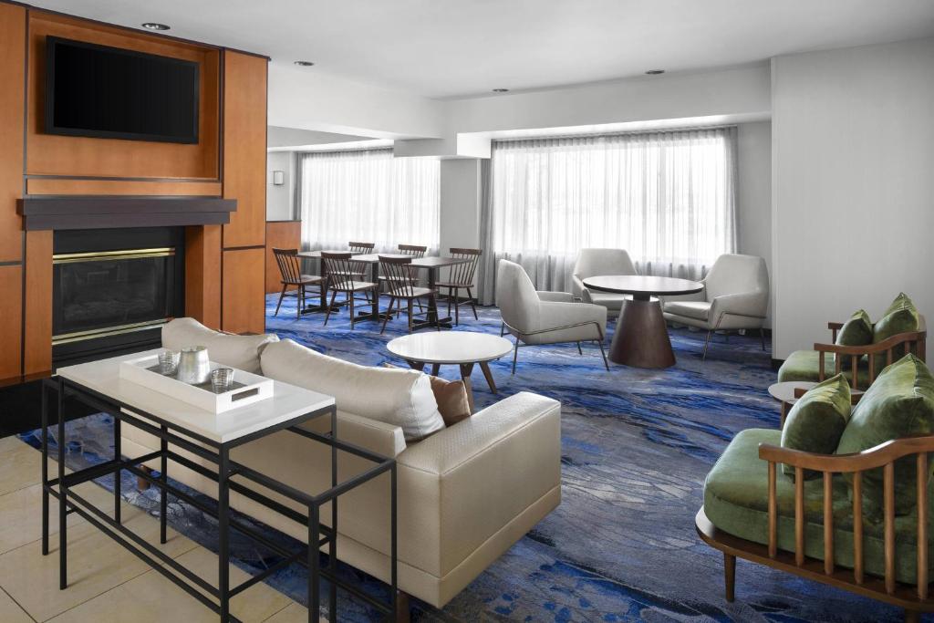 een hotellobby met tafels en stoelen en een open haard bij Fairfield Inn & Suites Denver Airport in Denver