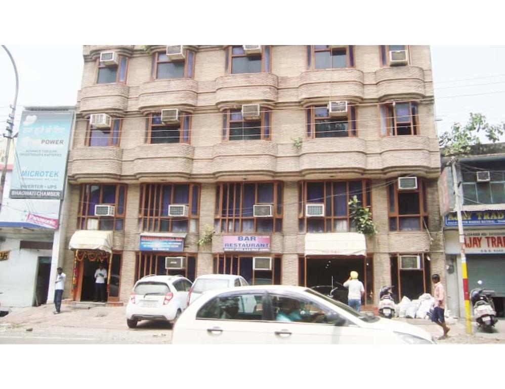 a large building with cars parked in front of it at Hotel Swagat, Jammu in Jammu