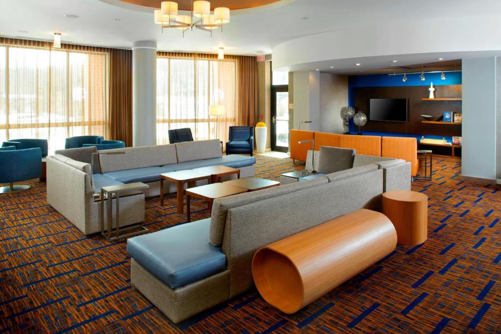 hol hotelowy z kanapami, stołami i krzesłami w obiekcie Courtyard Dayton-University of Dayton w mieście Dayton