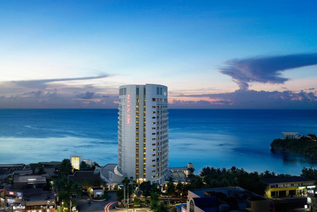 The Westin Resort Guam في تومون: مبنى أبيض طويل مع المحيط في الخلفية