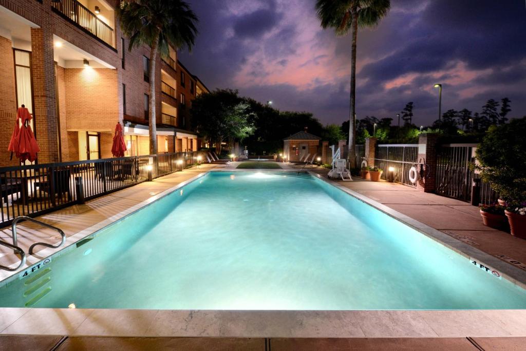 una piscina por la noche con un edificio en Courtyard by Marriott Houston Northwest, en Houston