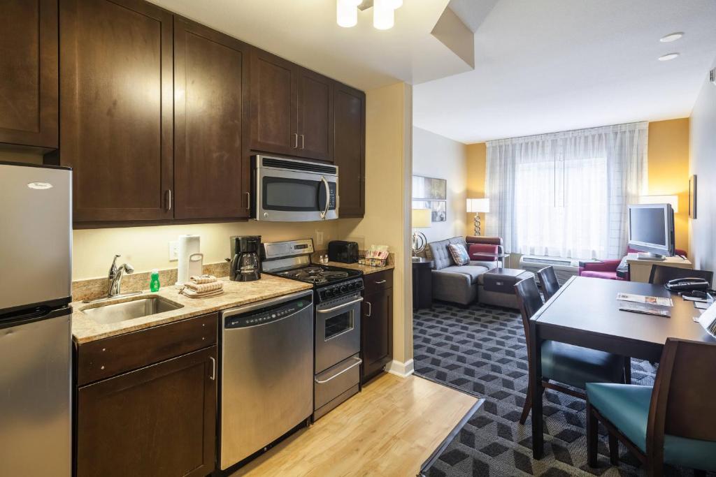 a kitchen and living room in a hotel room at TownePlace Suites Jacksonville Butler Boulevard in Jacksonville