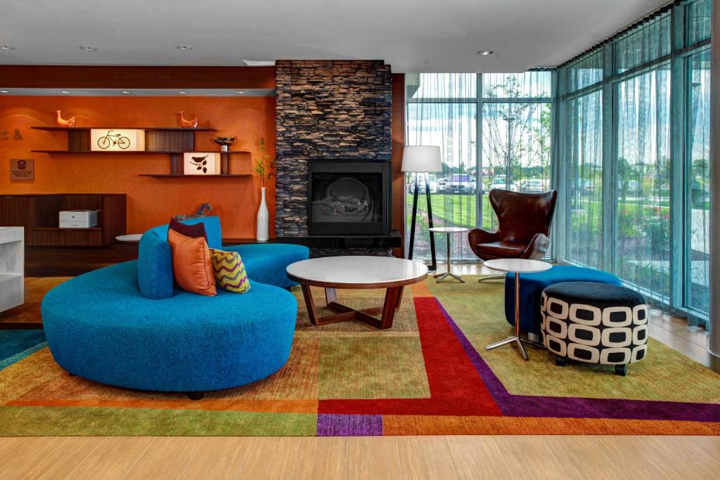 a living room with a blue couch and a fireplace at Fairfield Inn & Suites by Marriott Lansing at Eastwood in Lansing