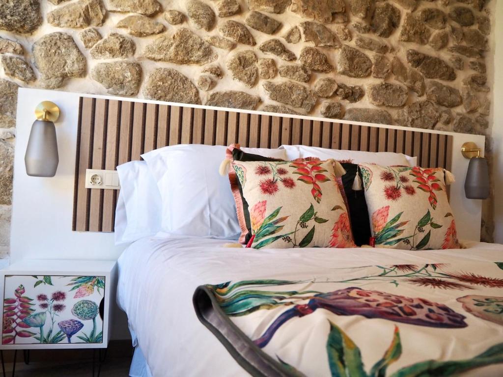 - une chambre avec un lit et un mur en pierre dans l'établissement La Casa Rebonita ACCESA, à Candelario