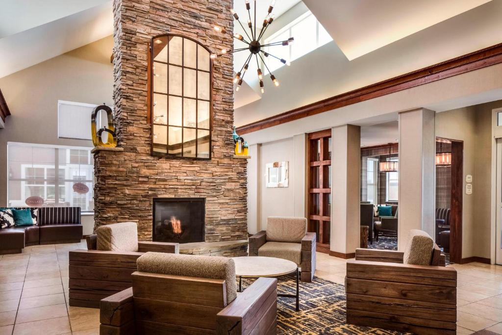 sala de estar con chimenea, mesa y sillas en Residence Inn by Marriott Billings, en Billings