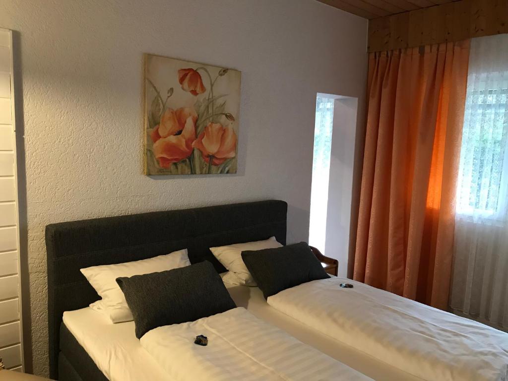 a bedroom with two beds and a painting on the wall at Hotel Schachten in Lindberg