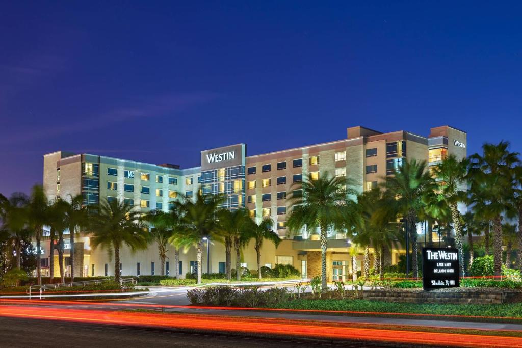 a building with palm trees in front of a street at The Westin Lake Mary, Orlando North in Lake Mary