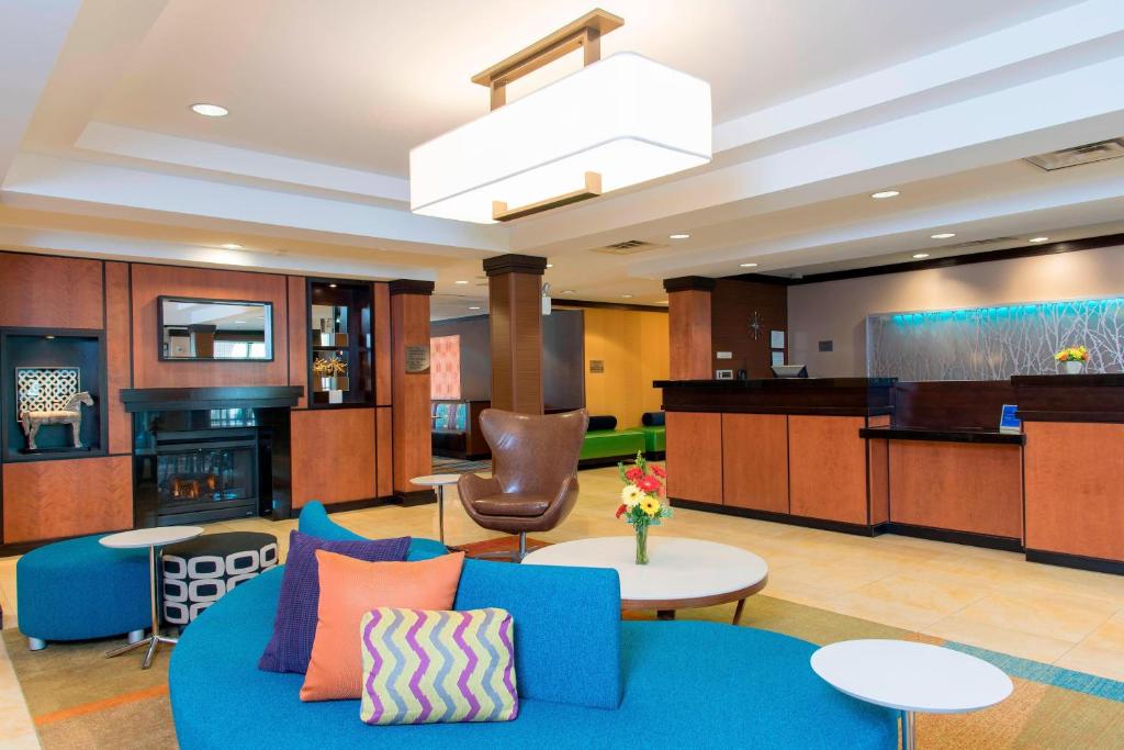 a living room with a blue couch and a table at Fairfield Inn & Suites by Marriott Omaha Downtown in Omaha