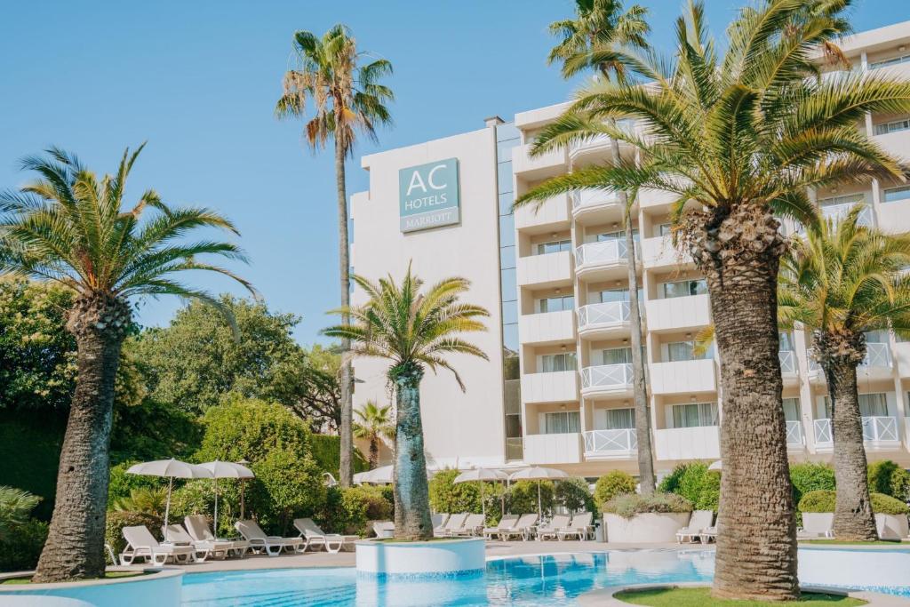 a hotel with palm trees in front of it at AC Hotel by Marriott Ambassadeur Antibes - Juan Les Pins in Juan-les-Pins