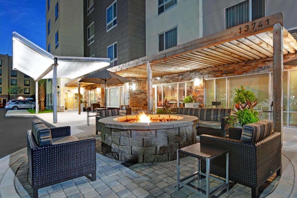 une terrasse avec un foyer extérieur en face d'un bâtiment dans l'établissement TownePlace Suites by Marriott Jacksonville East, à Jacksonville