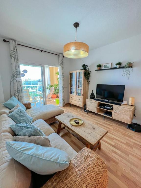Telewizja i/lub zestaw kina domowego w obiekcie Bright apartment with terrace, pool and beach