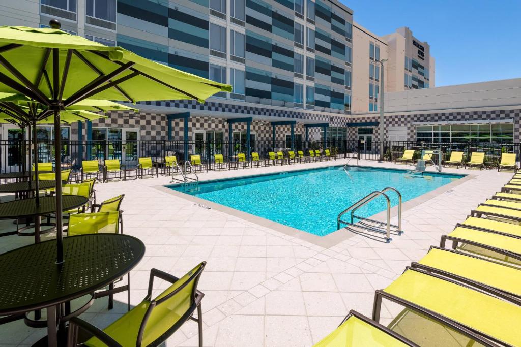 萊克蘭的住宿－SpringHill Suites Lakeland，一座带桌椅的游泳池以及一座建筑