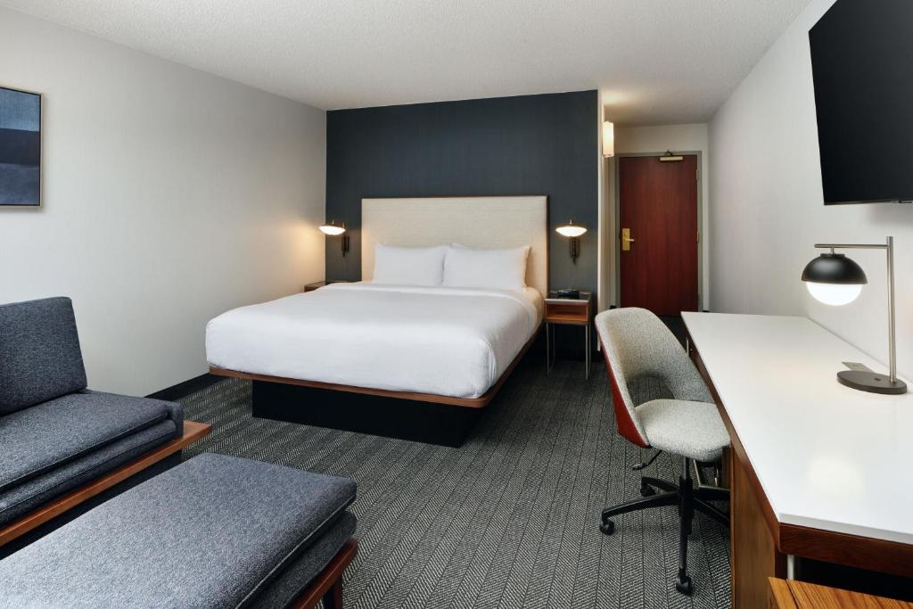 a hotel room with a bed and a desk at Courtyard Boulder Longmont in Longmont