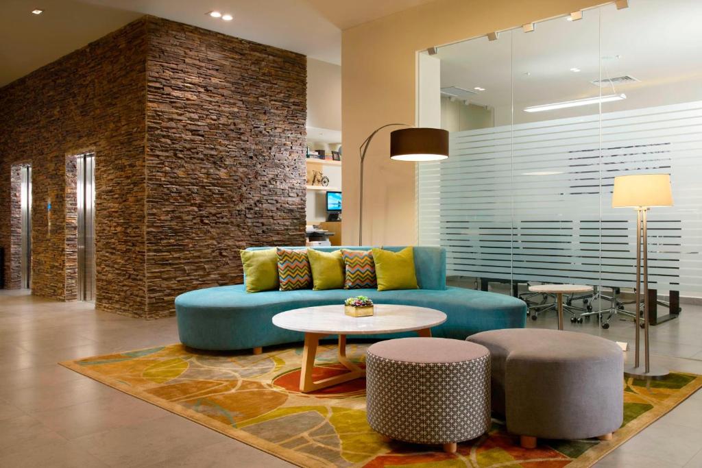 - un salon avec un canapé bleu et une table dans l'établissement Fairfield Inn & Suites by Marriott Villahermosa Tabasco, à Villahermosa