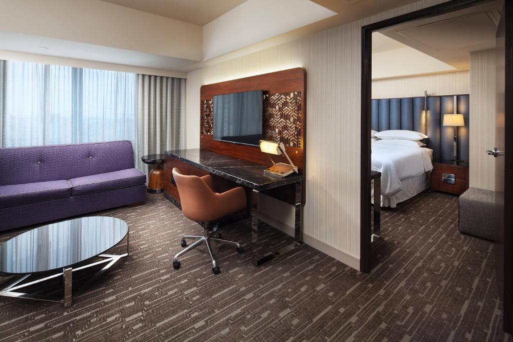 a hotel room with a bed and a desk and a couch at Sheraton Grand Los Angeles in Los Angeles