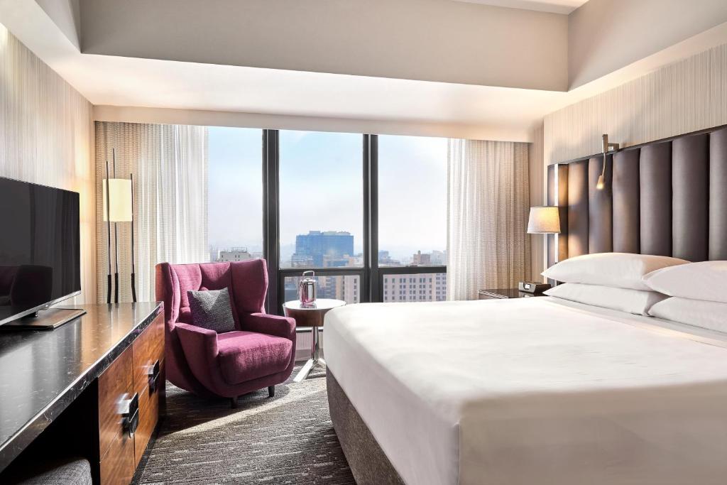 a bedroom with a large bed and a large window at Sheraton Grand Los Angeles in Los Angeles