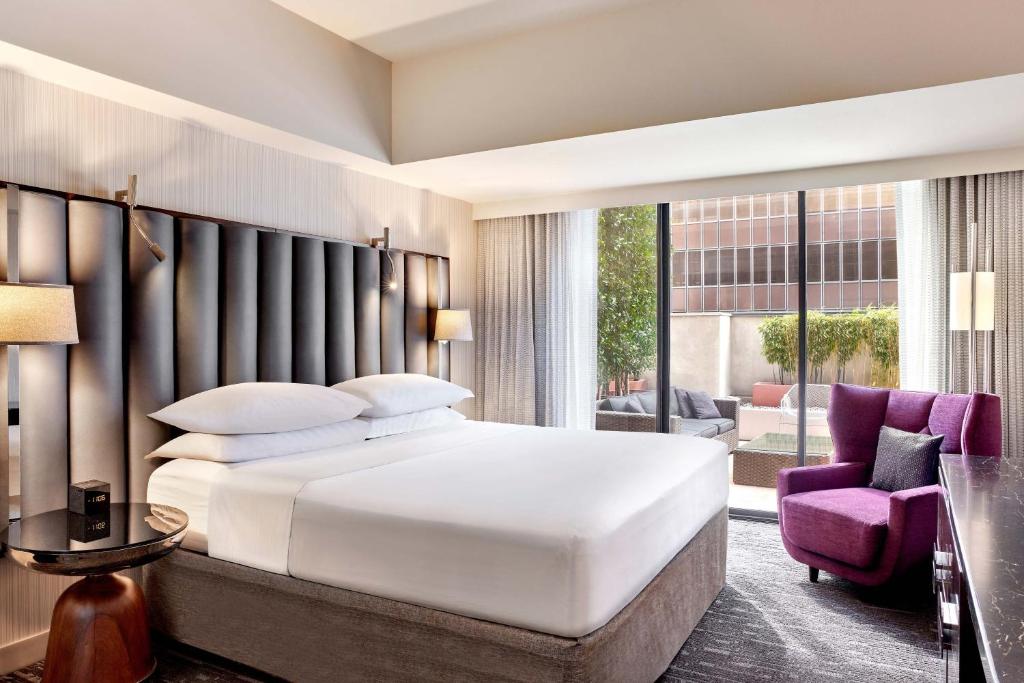 a bedroom with a large bed and a purple chair at Sheraton Grand Los Angeles in Los Angeles